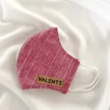 Tapabocas de tela color borgoña con finas líneas blancas verticales y horizontales.