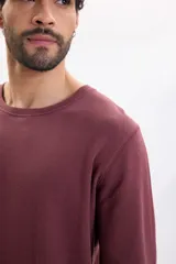 Remera manga larga de tejido texturizado tipo wafle en color bordó, con cuello redondo y puños elásticos.