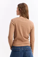 Remera de manga larga con cuello redondo y ajuste al cuerpo, confeccionada en tejido de algodón con textura acanalada.