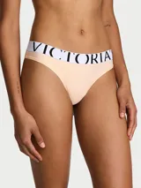 Tanga de microfibra color salmón, con tiro bajo y cinturilla elástica blanca con el logo de la marca estampado en negro.