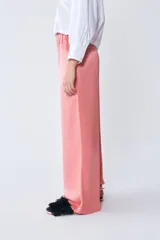 Pantalón de vestir color salmón, de corte recto y tiro alto, con cintura elástica y cordón ajustable.