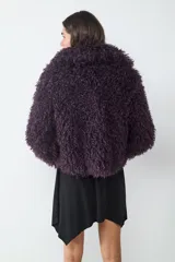 Campera corta de pelo sintético con textura rizada y voluminosa, de corte holgado y diseño envolvente.