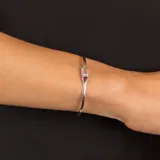 Pulsera rígida abierta de plata 925 con dos piedras engarzadas: una triangular de granate rojo y otra rectangular de cuarzo rosa.
