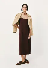 Vestido midi de corte recto y escote cuadrado, con tirantes finos y costuras verticales decorativas a lo largo de la prenda. Color bordó.