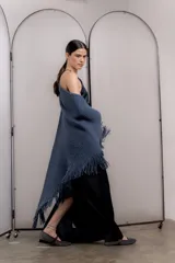 Chal de tejido de punto grueso color azul con flecos en los bordes.