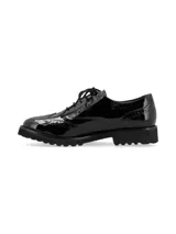 Zapato estilo oxford de cuero charol negro, con diseño clásico de perforaciones brogue, cordones al tono y suela track de EVA.