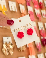 Par de aros de plástico con forma de rosa color fucsia.