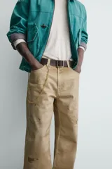 Pantalón straight fit de algodón con efecto lavado y roturas localizadas. Presenta diseño de cinco bolsillos, cierre frontal con cremallera y botón metálico.