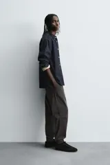 Pantalón tipo jogger de corte slim fit, confeccionado en tejido de algodón con elasticidad. Presenta cintura elástica ajustable con cordón, bolsillos frontales, bolsillos traseros de vivo y bajos con puños elásticos.
