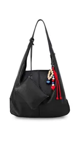 Cartera tipo hobo de cuero sintético color suela, con interior espacioso y costuras decorativas frontales. Incluye asa de hombro fija, monedero rectangular colgante a juego y un llavero amuleto con cuentas de madera, ojos turcos y detalles en rojo.