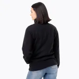 Buzo polar de mujer con cuello alto y cierre frontal parcial con botones a presión. Presenta un diseño de manga larga con puños elásticos y un parche con logo en el pecho.