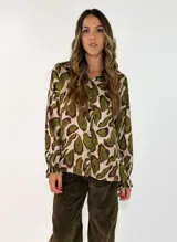 Camisa de manga larga con cuello camisero y cierre frontal de botones, confeccionada en tela fluida con estampado animal print en tonos marrones y negros.