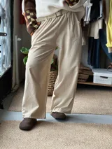 Pantalón de pana fina color beige, con cintura elástica y bolsillos laterales, de corte amplio y holgado.