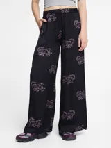 Pantalón palazzo negro con estampado de tigres rosas, cintura elástica y bolsillos laterales.