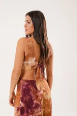 Vestido largo con estampado batik en tonos marrones y borgoña, escote en V, sin mangas y abertura lateral.