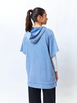 Chaleco negro lavado de algodón con capucha y gran bolsillo central. De corte oversized, holgado, suave y cómodo.