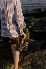 Sandalias bajas color beige con tiras de cuero entretejidas.