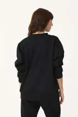 Buzo cuello redondo negro con logo retro bordado en el pecho.