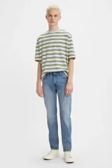 Jean de corte skinny con tiro medio, confeccionado en denim azul con efecto de lavado desgastado.