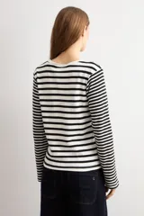 Remera rayada de manga larga en color blanco y negro, con cuello redondo y detalle de bordado floral en el pecho.