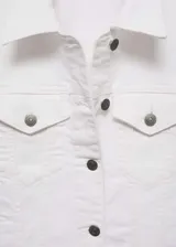 Chaqueta vaquera de corte corto en color blanco, con cuello de solapa, manga larga con puños abotonados, cierre frontal de botones metálicos, bolsillos de parche con solapa en el pecho y bolsillos laterales ribeteados.