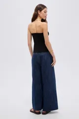 Top de viscosa negro, sin mangas, con escote strapless y frunce central en el escote que genera una abertura frontal.