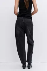 Pantalón de jean color negro lavado, de corte holgado y tiro medio, con costuras reforzadas en las rodillas.