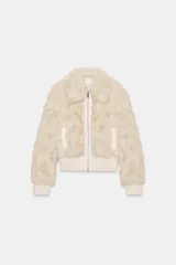 Chaqueta tipo bomber de textura afelpada en color crema, con cuello solapa, cierre frontal con cremallera y puños y cintura de tejido elástico acanalado.