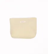 Neceser de tela color beige claro, con textura de pana o corduroy acanalada. Presenta una pequeña etiqueta blanca cosida en el centro con el texto "simple wish".