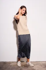 Falda midi de poliéster color negro con estampado de lunares blancos.