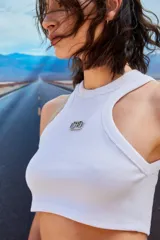 Top corto blanco de morley con escote redondo y logo metálico de Renée en el frente.