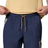 Pantalón cortavientos azul marino con tecnología Omni-Shield repelente al agua y manchas, bolsillos laterales con cierre y detalles en tono mostaza y verde.
