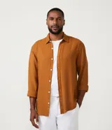 Camisa color ocre de lino texturizado, corte comfort, cuello camisero, manga larga con puños abotonados y cierre frontal con botones.