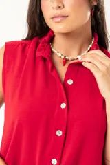 Camisa roja sin mangas con cuello mao adornado con un volado y cierre frontal con botones.