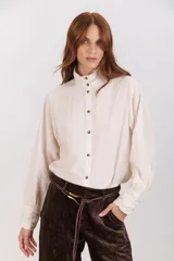 Camisa color crudo de cuello alto con botones y frunces en los puños y el cuello.