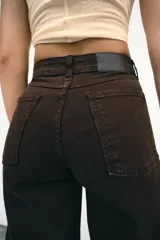 Jeans de tiro alto con diseño wide leg y corte cropped. Presenta cinco bolsillos, cierre frontal con cremallera y botón metálico.