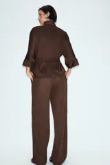 Pantalón de tiro alto con diseño de pierna ancha, confeccionado en tejido con efecto ante. Cuenta con cintura elástica y bolsillos laterales ocultos en la costura.