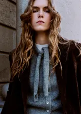 Cardigan de punto gris melange, de manga corta, con cuello redondo y cierre frontal de botones con tiras integradas para atar en forma de lazo.