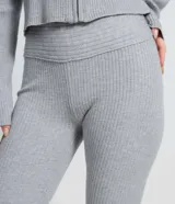 Pantalón de tiro alto en tricot acanalado con corte flare, ajustado en caderas y muslos con apertura desde la rodilla.