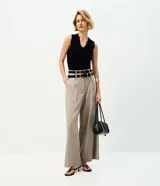 Pantalón de sastrería de corte ancho y recto, color gris, con cintura doble estructurada y removible, pinzas frontales y bolsillos.