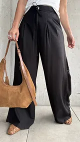 Pantalón negro de lino con pinzas en la cintura, cordón ajustable y corte wide leg.