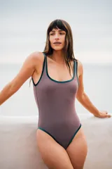 Traje de baño entero color visón con bordes de terciopelo verde inglés y detalle de óvalo en la espalda.