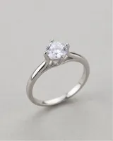 Anillo de plata 925 con piedra circonia central de corte redondo con engarce de cuatro puntas y diseño de banda clásica.