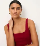 Blusa negra de corte regular, confeccionada en tejido Rib de algodón, con escote cuadrado y breteles anchos.