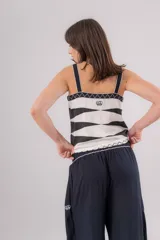 Musculosa negra con escote en V, breteles anchos y bordados geométricos blancos en cuello, sisas y frente.