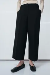 Pantalón de tiro medio confeccionado en viscosa, con diseño de corte recto y largo tobillero. Presenta cintura con trabillas, bolsillos laterales y bolsillos de vivo en la parte posterior. Cierre frontal con cremallera, botón y ganchos metálicos.