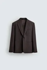 Blazer de corte regular fit confeccionado en tejido con mezcla de lana. Presenta cuello con solapas de muesca, cierre frontal de un botón, mangas largas con puños abotonados, bolsillos de vivo en el pecho y la cadera, bolsillo interior y aberturas en la espalda.