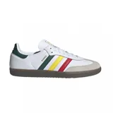 Championes adidas Samba OG de diseño clásico, con exterior de cuero blanco, puntera de gamuza gris y suela de goma color caramelo. Presenta las icónicas tres tiras laterales en colores verde, amarillo y rojo, con el nombre del modelo en dorado.