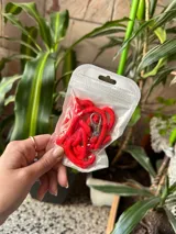 Correa para celular de soga trenzada en color fucsia con terminales metálicas plateadas y mosquetón.