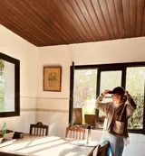 Cardigan de punto color beige con escote en V, cierre frontal con botones, bolsillos delanteros aplicados y detalle de flecos en el ruedo.